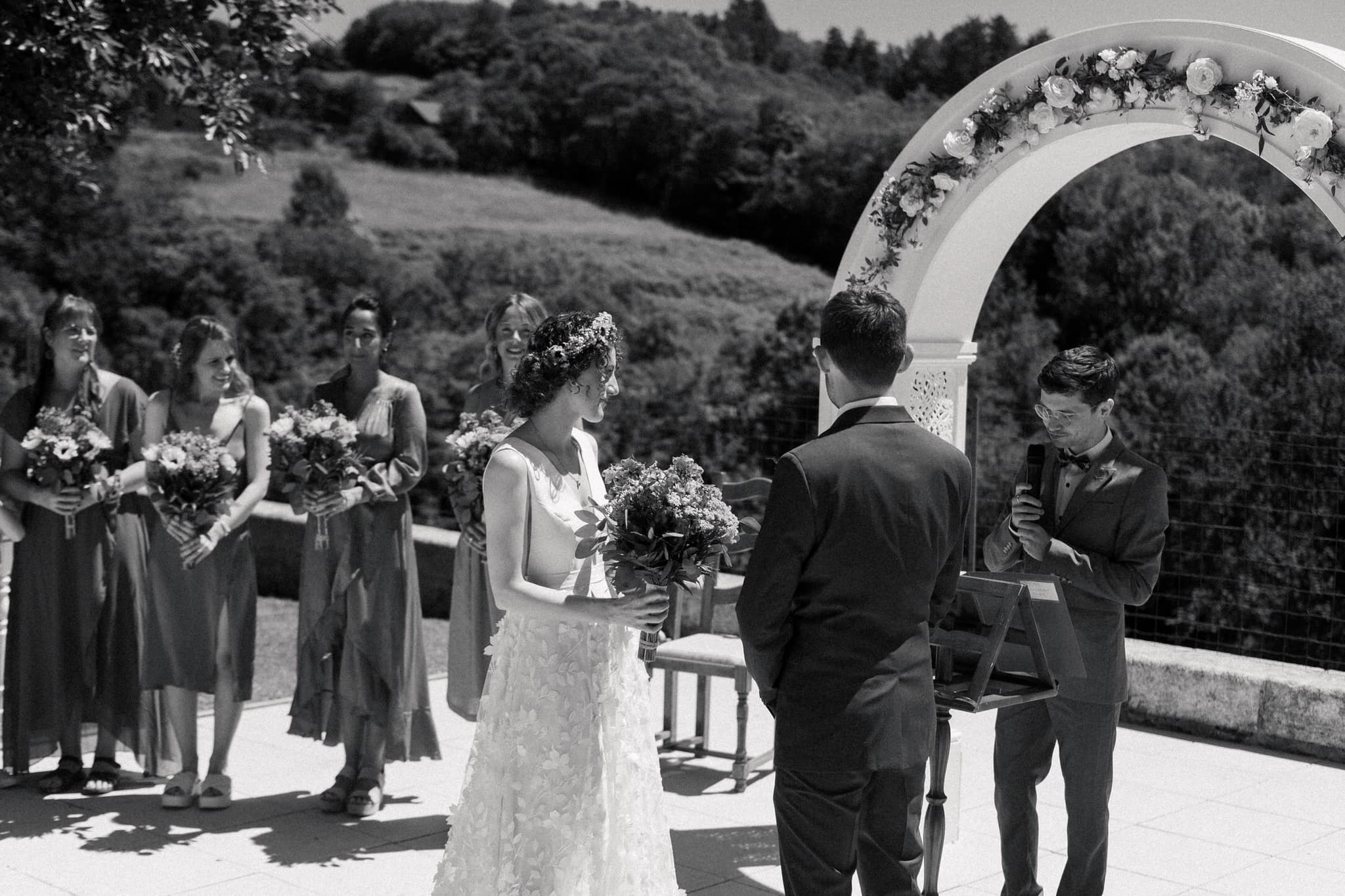 Black and white photograph of a groom reading vows to his bride